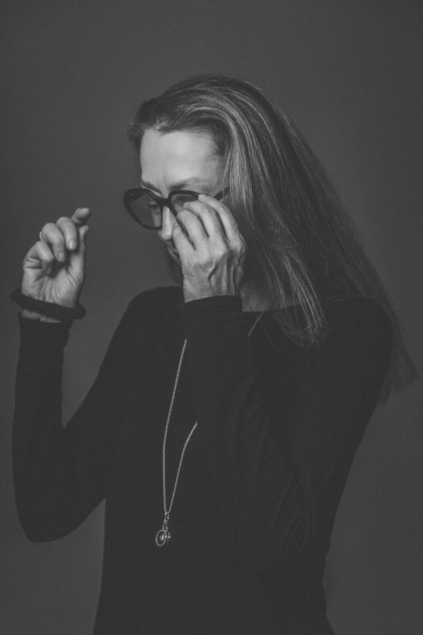 Frau beim Aufsetzen einer eleganten Brille - modische Brillen bei Augenoptik Hensler