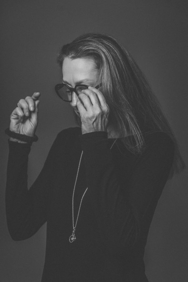 Frau beim Aufsetzen einer eleganten Brille - modische Brillen bei Augenoptik Hensler